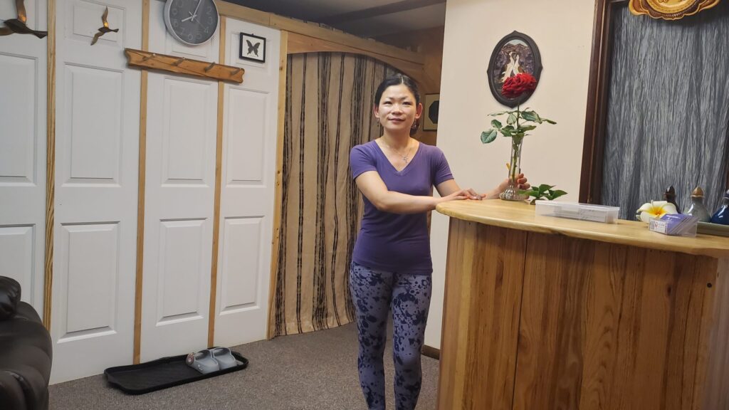 Licensed massage therapist Char standing in reception area.